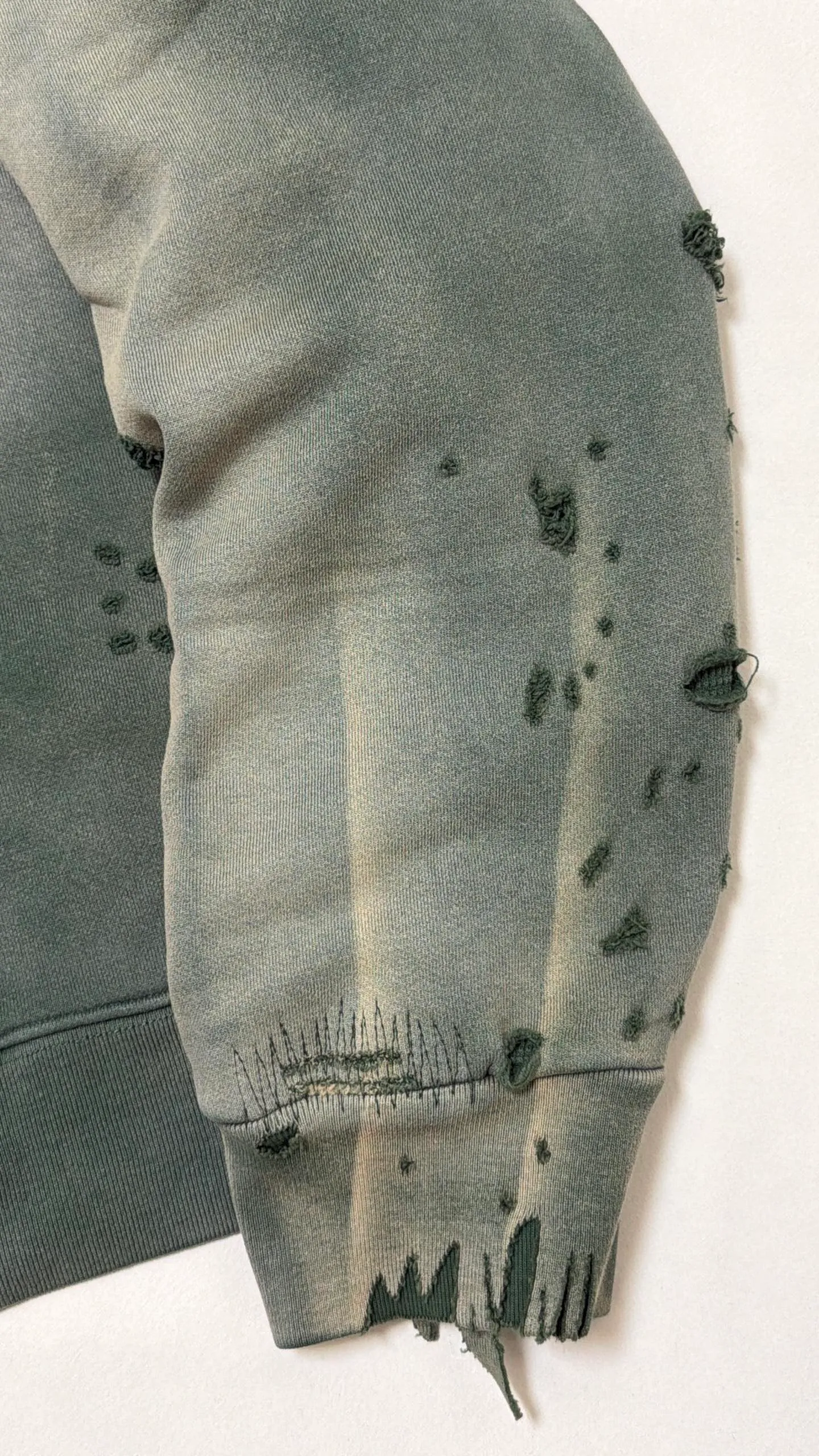 More details SAINT Mxxxxxx DBL FACE ZIP UP HOODIE/GREEN Double-layer damaged waffle zipper jacket, washed green S-XL, a style that has been used in the summer. After continuous fine polishing, it is finally shipped. The finished product is simply a work of art. Super heavy washing and distressing. Multiple horse water fading. Many hand-made wormhole damage processing. Deconstruction and reorganization embroidery technology. Customized zipper with LOGO. The color details of the zipper webbing are also correct. Original grade fruit main label and wash water label. Top purchasing grade. A layer of waffle fabric is added to the inner lining to make the overall texture stronger and increase the comfort and warmth of the wearer.